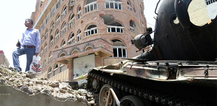 A Yemeni stands next to a tank during clashes between fighters