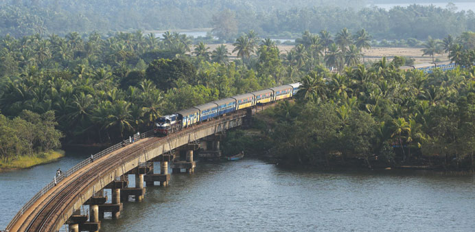 A diesel locomotive carrying a passenger train passes over the Sherawati bridge near Honnawar in Karnataka. The government has awarded $5.6bn contract