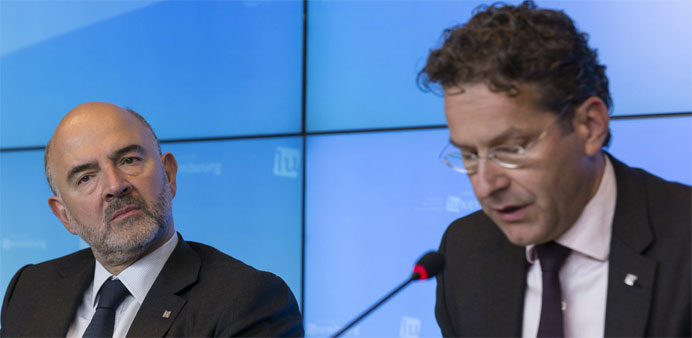 EU Economic and Financial Affairs, Taxation and Customs Commissioner Pierre Moscovici (L) listens to Dutch Minister of Finance and President of the Co
