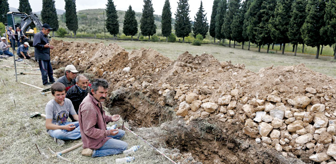 People pray during the funeral of a miner following the Soma mine explosion.
