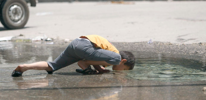 A boy drinks water from a burst water pipe in Aleppou2019s Karm al-Jabal district yesterday. 