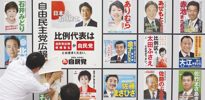 Staff members of Japanu2019s ruling Liberal Democratic Party put up posters of election candidates at the party headquarters in Tokyo.