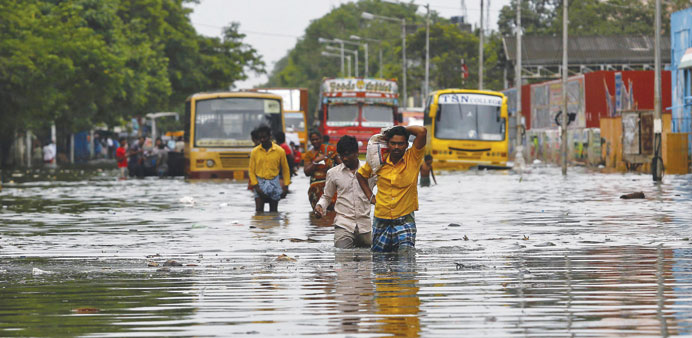 People wade through a flooded road in Chennai yesterday.