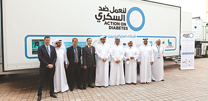 HE Dr al-Sada, senior officials and dignitaries pose beside the new bus for diabetes screening.