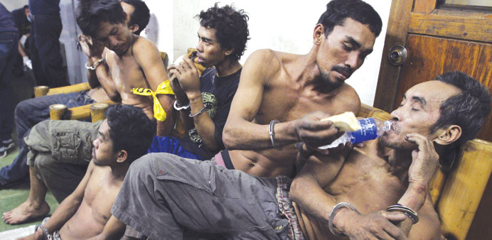 A member of the Moro National Liberation Front helps a fellow rebel drink water after they surrendered to the government soldiers, as they wait to be 