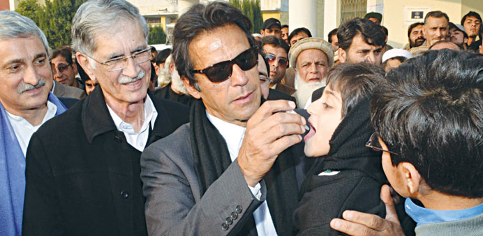 File picture of Pakistani cricketer-turned-politician Imran Khan gives polio vaccine drops to a young girl.