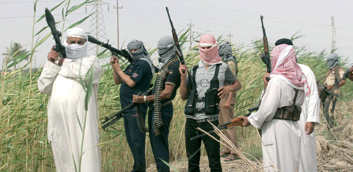 Tribal men pose with their weapons as they patrol a road north of Ramadi, 100km west of Baghdad, yesterday.