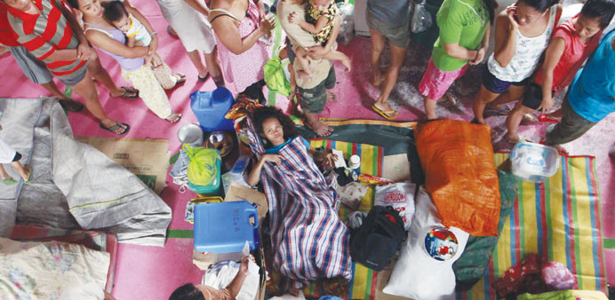 Filipino victims of a recent flood are seen inside a basketball court turned into an evacuation centre in Pasay city, south of Manila yesterday. 