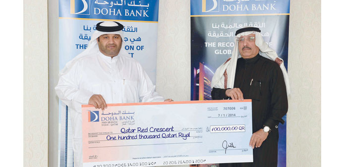 Doha Bank and QRC officials at a cheque presentation ceremony.