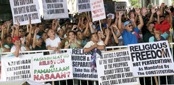 Filipino members of the Iglesia ni Cristo (Church of Christ) or INC display signs during a protest in Manila yesterday. 
