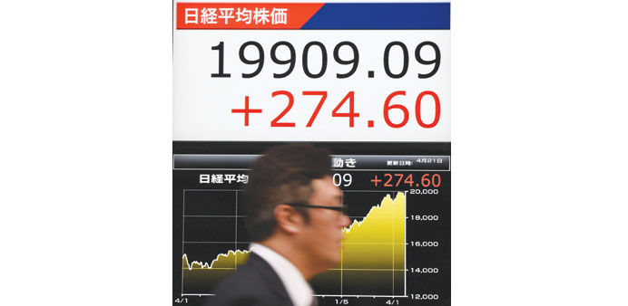 A man walks past an electric stock quotation board in Tokyo. Japanese stocks closed up 274.60 points to 19,909.09 yesterday.