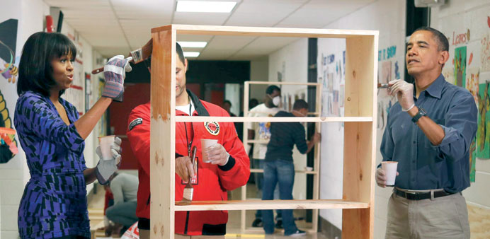 President Barack Obama and First Lady Michelle Obama paint shelves at Burrville Elementary School as they participate in a day of service, hoping to e