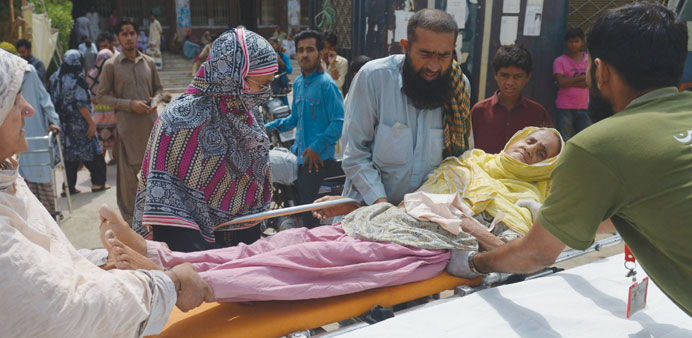 Pakistani relatives shift a heatstroke victim to a hospital in Karachi yesterday.