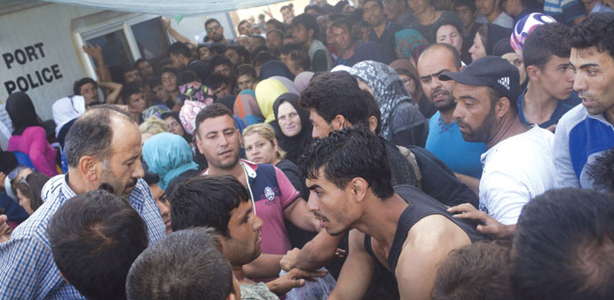  Afghan and Syrians scuffle yesterday over priority for a registration procedure at the port of Mytilene on the Greek island of Lesbos.