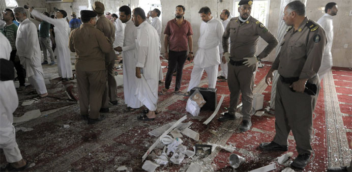 Saudi policemen gather around debris following a blast inside a mosque