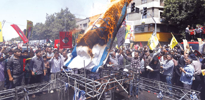Demonstrators burn an Israeli flag during a rally marking Quds Day (Jerusalem Day) in Tehran yesterday.