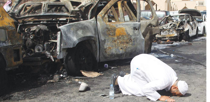  The cousin of a victim prays at the site of the suicide bombing in Dammam yesterday. 