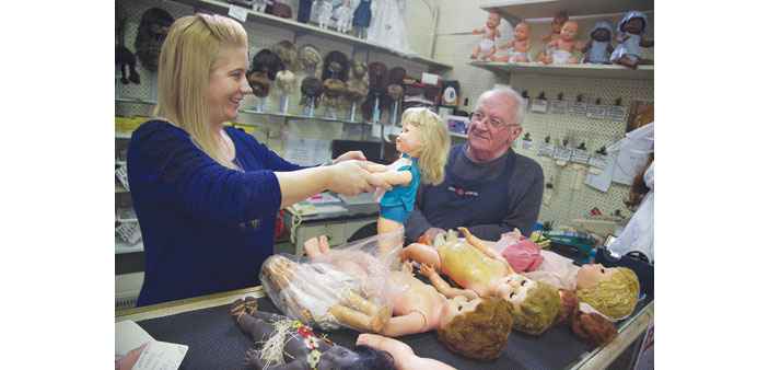 Geoff Chapman (right), u2018head surgeonu2019 and third-generation owner of Sydneyu2019s Doll Hospital, looks on as employee Nadine Kosztka inspects a doll brough