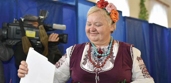 A woman in traditional Ukrainian dress casts her ballot at a polling station in Kiev during Ukrainian local elections yesterday.