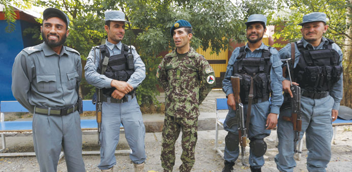 Essa Khan (centre), 24, an Afghan soldier ,talks with his colleagues at the Afghan Parliament entrance gate in Kabul, yesterday.