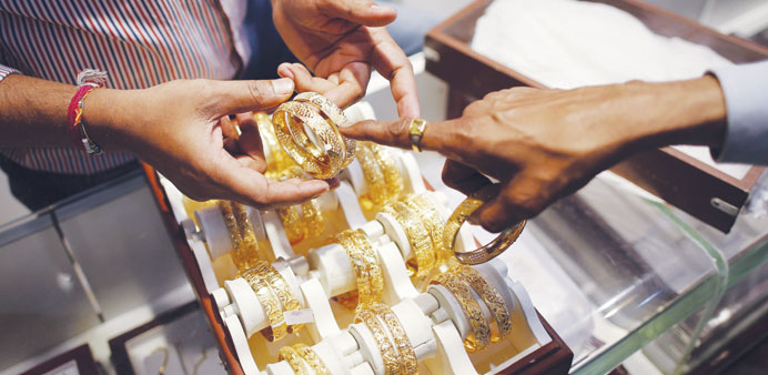 An employee shows gold bangles to a customer at a jewellery showroom on the occasion of Dhanteras, a Hindu festival, at a market in Mumbai yesterday.
