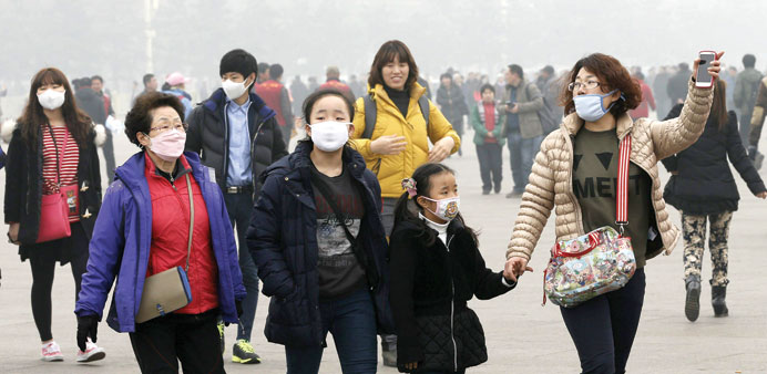 Visitors wear protective masks as they go around the Tiananmen Square amidst smog in Beijing.