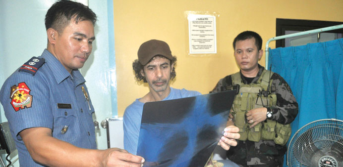 Jordanian TV journalist Bakr Atyani  with policemen at a hospital in Jolo yesterday.
