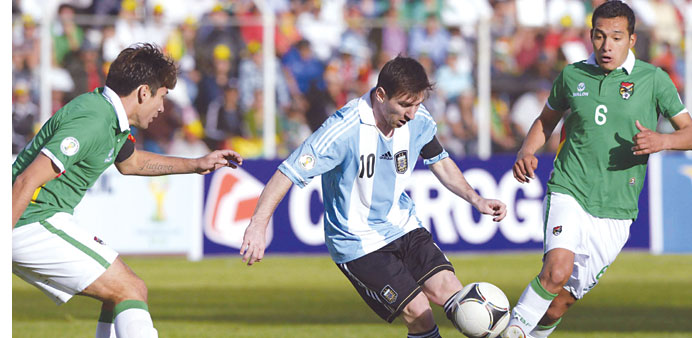 Boliviau2019s Ronald Raldes (left) and Walter Veizaga (right) look as Argentinau2019s Lionel Messi kicks the ball during their 2014 World Cup qualifier match 