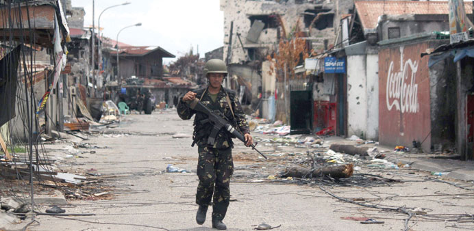 A Philippine soldier walks amongst burned and bullet-riddled houses in Zamboanga.