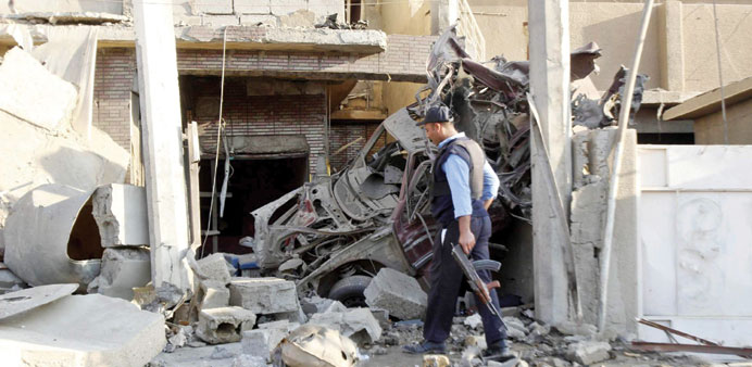 A policeman inspects the site of a bomb attack in Kirkuk yesterday.