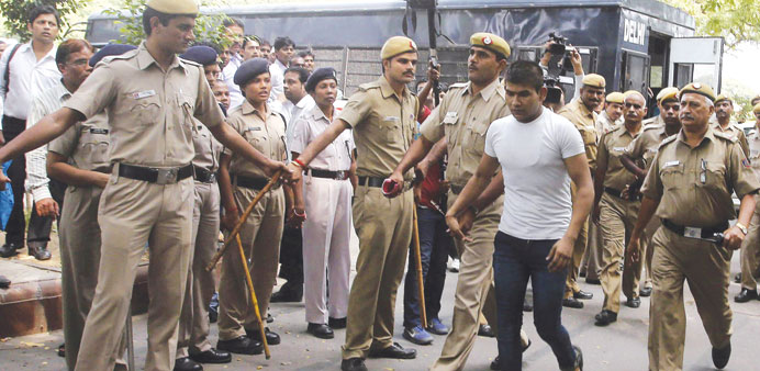 Vinay Sharma, one of the four men sentenced to death for fatally raping a young woman on a bus last December, is escorted by police outside the Delhi 