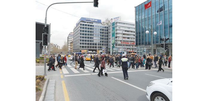 A police officer stops traffic to allow people to cross the road during a power outage in Ankara.