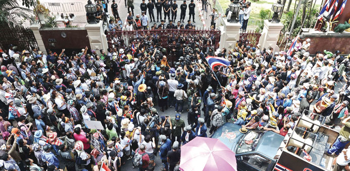 Thai Buddhist monk and one of the anti-government protest leaders Luang Pu Buddha Issara (top centre, in robes) stands beside the gate of the Royal Th