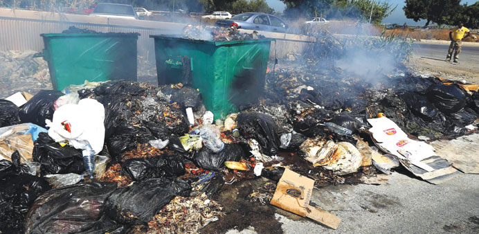 A man looks at burning rubbish up on a street in Dbayeh, north of Beirut.
