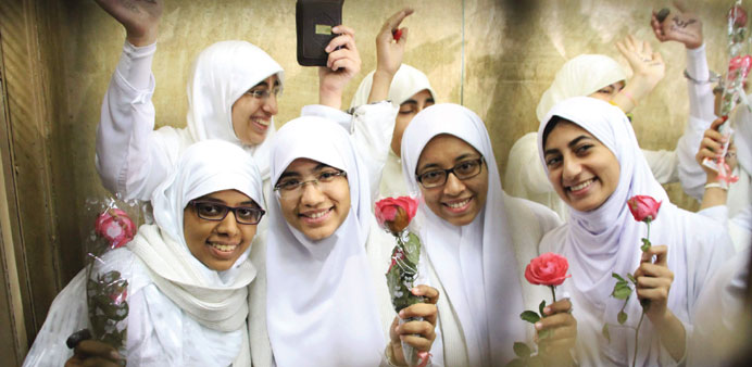 Female protesters supporting Mursi hold flowers as they celebrate inside the defendants cage following the court ruling in Alexandria yesterday.