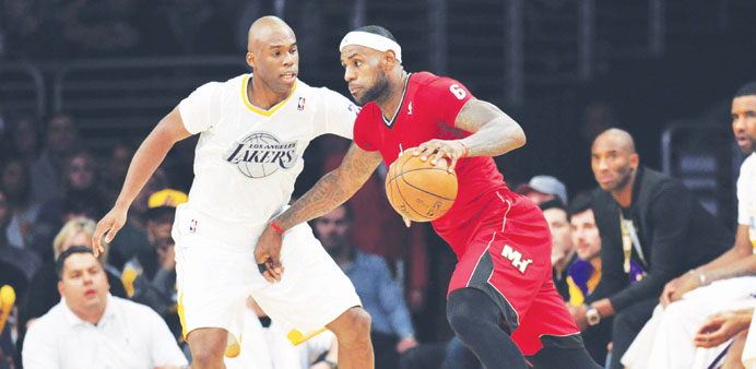 Miami Heatu2019s forward LeBron James (right) attempts to move past Los Angeles Lakers shooting guard Jodie Meeks during an NBA match on Wednesday. (USA T