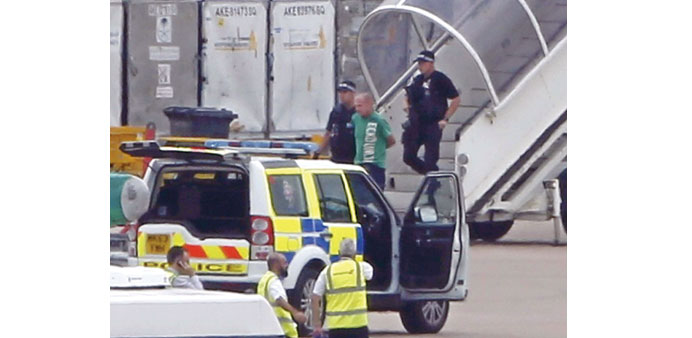 A man is being escorted off the Qatar Airways aircraft by police at Manchester airport yesterday.