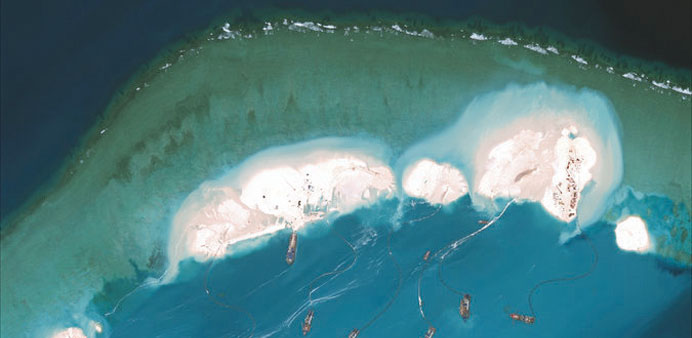 A satellite image shows an emerging artificial island at Mischief Reef. Right: A US Navy jet over the South China Sea. China says the flights violate 