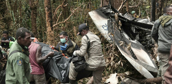 Rescue team members carry bodies of the victims of the crashed Trigana Air at the crash site near Oksibil