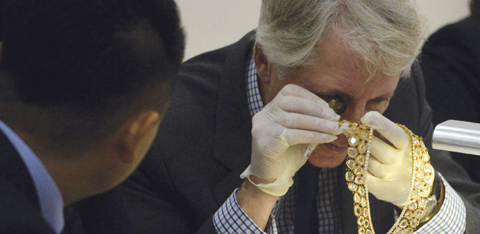 Christieu2019s and Sothebyu2019s auction house appraiser David Warren (right) examines diamond jewellery seized by the Philippine government from former first