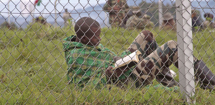 Downtime: One of the M23 rebels who surrendered to the Ugandan army reads a book in an isolated compound in the village of Rugwerero, Kisoro district,