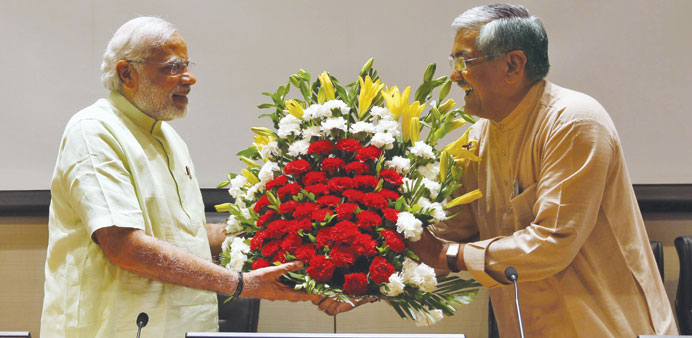 Narendra Modi receives a bouquet of flowers from BJPu2019s Gujarat state president R C Faldu upon his arrival to meet party leaders and workers at Gandhin