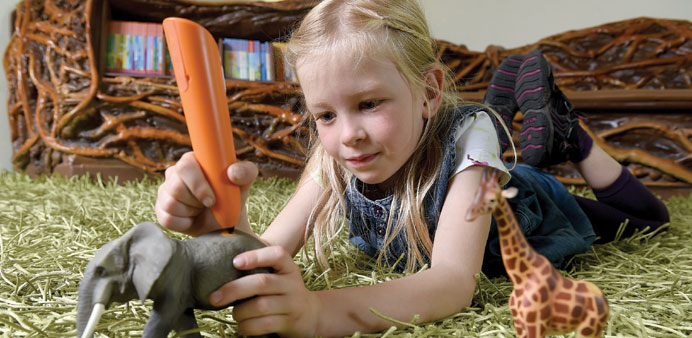 IN ACTION: A German girl shows how the Ravensburg companyu2019s Tiptoi pen is used to enhance toys with audio features. 