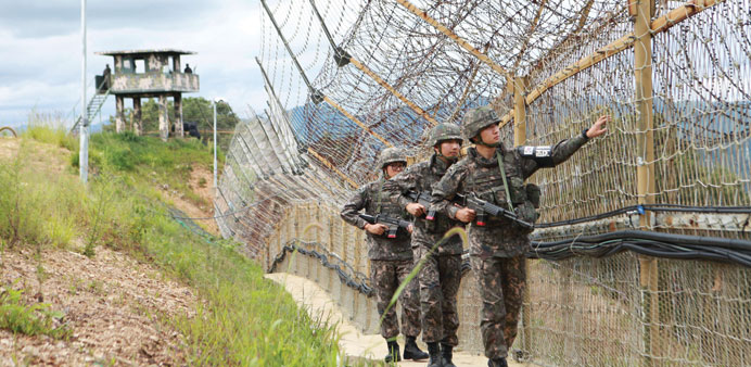 South Korean soldiers patrol the barbed-wire fence of the Demilitarized Zone (DMZ) separating North and South Korea, in Hwacheon yesterday.