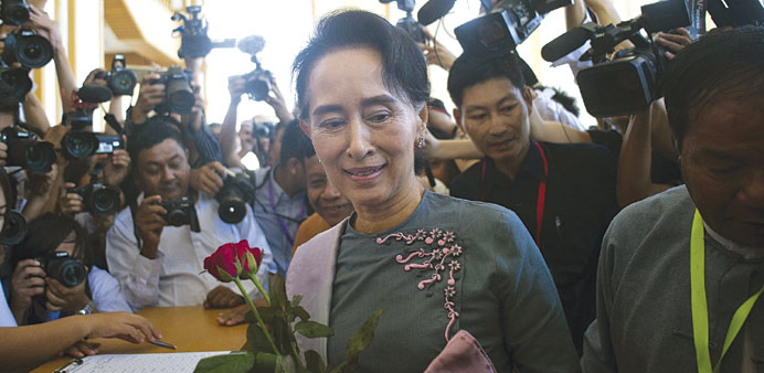 File photo shows Aung San Suu Kyi accepting flowers from parliamentary staff as she arrives for Myanmaru2019s first parliament meeting since the general e