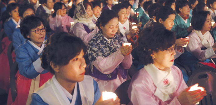 Buddhists pray for the safe return of missing passengers who were on a ferry which capsized on Wednesday, in Busan yesterday.