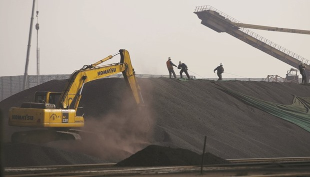 Labourers work on a pile of iron ore at a steel factory in Tangshan, China. The commodityu2019s boom turned to a bust as regulators in China moved to prevent the frenzy from getting out of hand and signs emerged of increased supply, including higher port stockpiles.