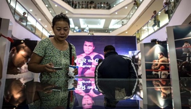 Shoppers look at memorabilia and photo exhibit featuring Muhammad Ali at the Ali Mall in Manila on Friday. 