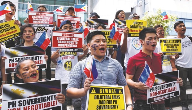 Members of Akbayan party list group chant slogans during a protest regarding the disputed islands in the South China Sea, in front of the Chinese consulate in Makati City, Metro Manila yesterday.