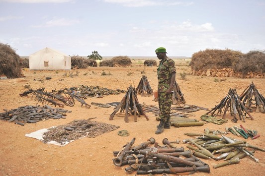 A handout photo taken yesterday and released by AMISOM shows Lt Col Joe Kibet, the Spokesperson of the AMISOM, examining weapons captured from Al Shebaab militants in Halgan village of Hiran region.